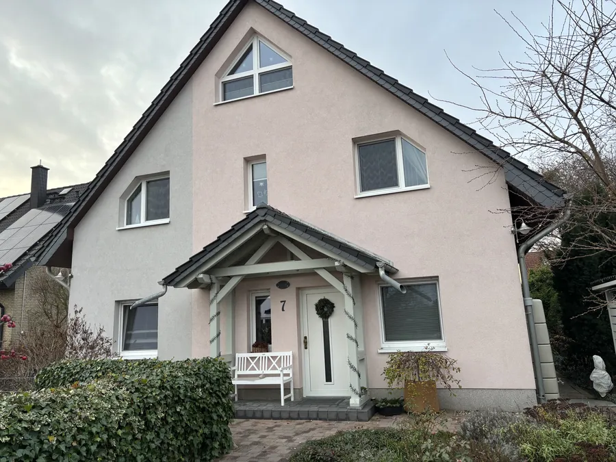Einfamilienhaus mit weißer Veranda nach dem Fassadenanstrich