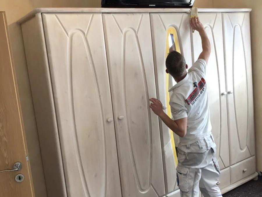 Mitarbeiter lasiert einen Einbauschrank