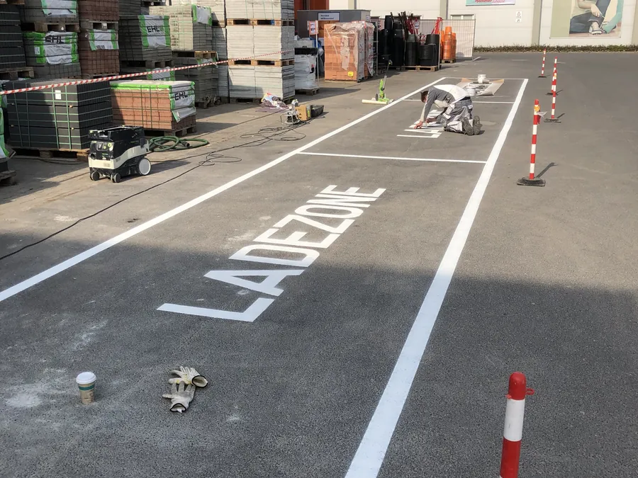 Weiße Bodenmarkierung mit der Aufschrift Ladezone